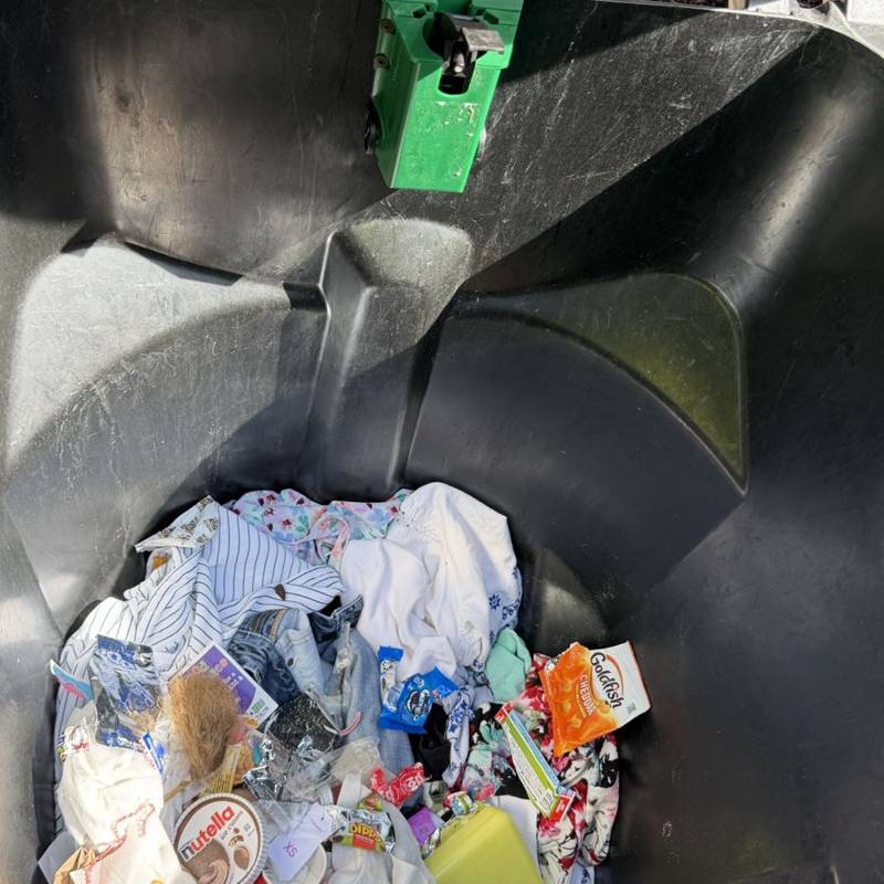 Trash bin before cleaning, full of loose garbage
