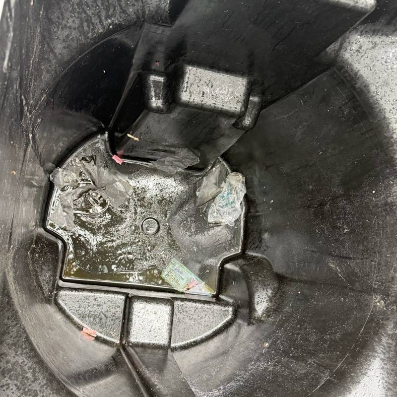 Inside of the same trash bin before cleaning: sticky grime pooled at the bottom
