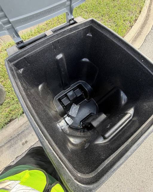 Clean bin interior with green deodorizer tag installed under the lid